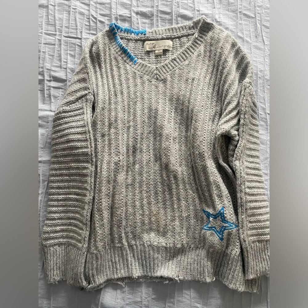 sweater with unique star embroidery on back and front with stitching on collar.
